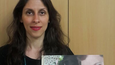 Nazanin Zaghari-Ratcliffe poses with a picture of herself with her husband and daughter in a photo released in March following her temporary release from prison. AFP/Free Nazanin Campaign
