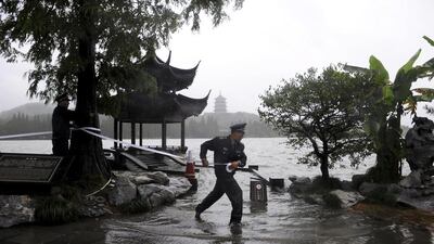 Security guards cordon off an overflow area near the West Lake in Hangzhou in east China's Zhejiang province as Typhoon Fitow slammed into southeastern China with powerful winds and heavy rains that have killed at least five people, cut power, cancelled flights and suspended train services. AP Photo