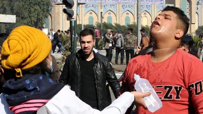 An Iraqi medical aid volunteer helps an anti-government protester suffering from tear gas effects during clashes with security forces in al-Khillani Square off central Baghdad's Sinak bridge which links the Iraqi capital's Green Zone with the rest of the city. AFP