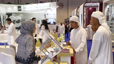 Students enquire about courses at an education fair in Abu Dhabi on October 31. Pawan Singh / The National