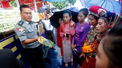 A police officer advises young people in Yangon about Myanmar's fight against drugs. EPA