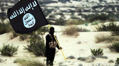 A masked ISIS member holding the group's banner, pictured in the deserts of Iraq or Syria. Getty Images