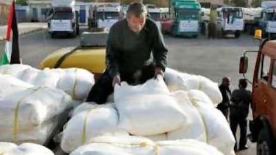 A worker loads humanitarian aid onto a truck before it departs for the Gaza Strip, at the King Hussein Bridge crossing near Amman.
