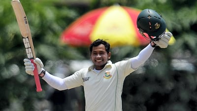Bangladesh captain Mushfiqur Rahim raises his bat and helmet in celebration after scoring a double century against Sri Lanka at the Galle International Cricket Stadium in Galle on March 11, 2013. AFP
