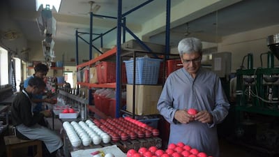 In this photograph taken on May 27, 2016, Chief Executive of ‘Grays of Cambridge’, Khawar Anwar Khawaja inspects a pink cricket ball at the factory in Sialkot. Pakistan’s sports goods industry is positioning itself to be the prime manufacturer of pink cricket balls — a high-visibility alternative for use in day-night Test matches aimed at dragging the game into the 21st century. Aamir Qureshi / AFP