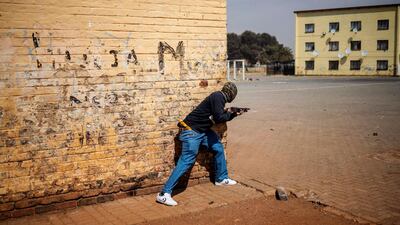 A member of the South African Police Service fires rubber bullets at residents in Eldorado Park, near Johannesburg, during a protest by community members after a 16-year old boy was found dead. AFP