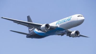 An Amazon-branded Boeing 767 freighter, nicknamed Amazon One, flies over Lake Washington. Independent traders, many attracted by Amazon's Prime service, doubled the number of goods they sold last year. Stephen Brashear/Gett / AFP