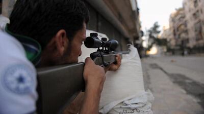 A fighter from the Syrian opposition takes aim in clashes. Bulent Kilic / AFP Photo