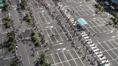 People maintain safe distancing while queueing to enter a supermarket in Grand Baie, Mauritius. AFP