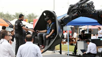 Visitors try out a plane simulator on display at the Mohammed Bin Zayed International Robotics Challenge in Abu Dhabi. Pawan Singh / The National