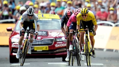 UAE Team Emirates rider Tadej Pogacar, wearing the race leader's yellow jersey, heads to the finish line.