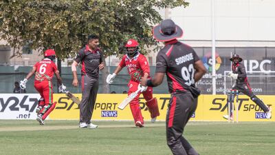 Oman players run between the wickets during the Cricket World Cup League 2 match at the ICC Academy in Dubai.