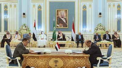 Sheikh Mohamed bin Zayed, Prince Mohammed bin Salman and Mr Hadi watch as Mr Al Khabji and Mr Al Khanbashi sign the power-sharing agreement. AFP