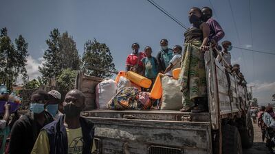 Displaced people who fled Goma after the eruption of the Nyiragongo volcano climb aboard a truck in Sake.