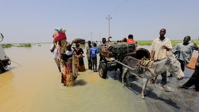 Residents load their bags onto a donkey-drawn cart, as they flee from the floods in Al Manaqil.