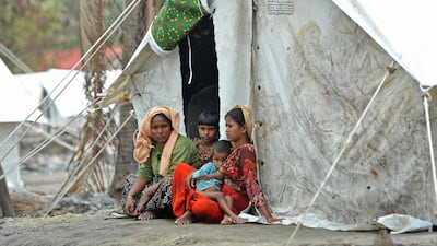 A Rohingya family sits outside a temporary shelter. Soe Than Win / AFP