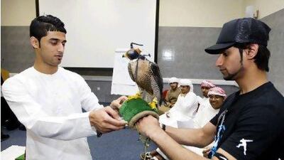 Yousif Albloushi, 18, left, and Khalid Alkaabi, 19, take turns holding a falcon during a field studies course that exposes students to the ecology of Fujairah. Sarah Dea / The National