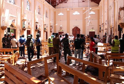 Sri Lankan security personnel walk through debris following an explosion in St Sebastian's Church in Negombo. AFP