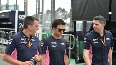 Racing Point's Mexican driver Sergio Perez (C) walks down pit lane at the Albert Park circuit ahead of the Formula One Australian Grand Prix in Melbourne. AFP