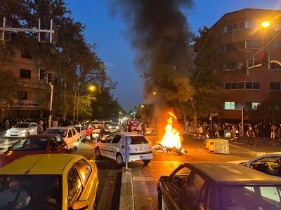 A a police motorcycle burns during a protest over the death of a young woman who had been detained for violating the country's conservative dress code, in downtown Tehran, Iran. AP