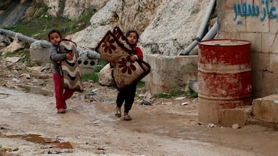 Internally displaced Syrian girls carry their belongings in an IDP camp located in Sarmada in Idlib province, Syria. REUTERS