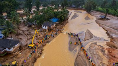 Rescuers cross a river in Chooralmala, following the landslides in Wayanad district, Kerala, India. AP