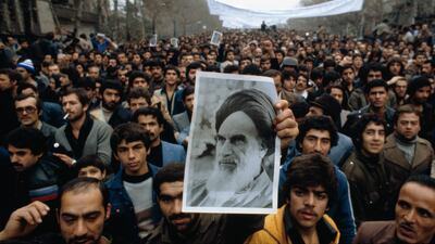 Demonstrators carry a photo of Ayatollah Khomeini during a demonstration against the monarch.