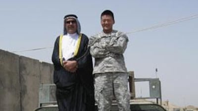Lt Dan Choi, who came out as gay in March and was subsequently dismissed from the US army, stands on the bonnet of a Humvee in south Baghdad with an Iraqi sheikh.