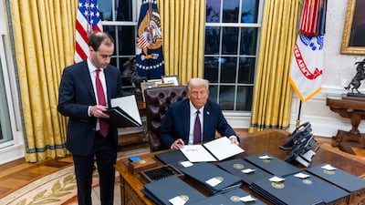 US President Donald Trump signs executive orders in the Oval Office of the White House. EPA