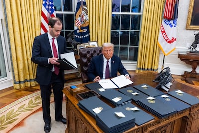 Donald Trump signs executive orders on the first day of his presidency in the Oval Office of the White House in Washington. EPA