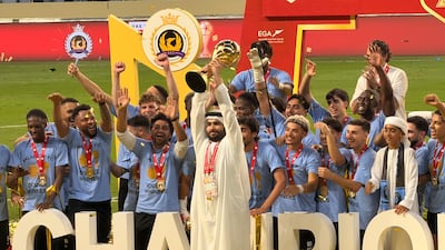 Palm City FC sporting director Ali Al Falasi holds aloft the UAE FA Cup following the team's penalty shoot-out win over Hatta in Dubai on August 25, 2026. Mina Rzouki / The National