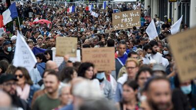 Protesters hold placards articulating their opposition to mandatory vaccination. AFP