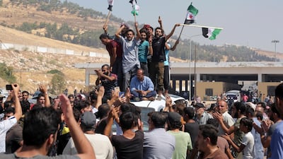 Protesters chant slogans as they hold Syrian revolutionary flags during a demonstration at the Bab Al Hawa border crossing between Turkey and Syria. AP