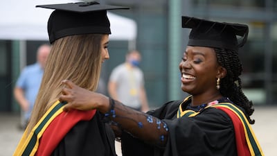 Students smile after graduating in Bolton, northwest England in 2021. But many graduates come to regret the subject they studied. AFP