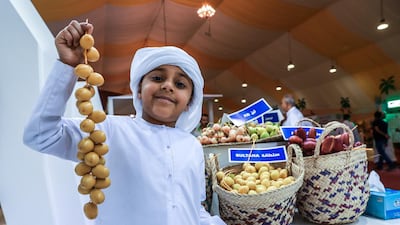 Jasim Al Qemzi, 7, holds up some Sultana dates from Zirku Island. Victor Besa / The National