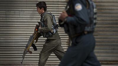 Afghan police men take position after an attack by a suicide squad on the former Afghan intelligence headquarters.