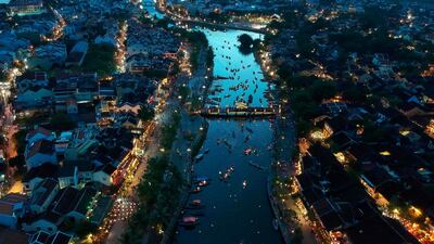 In this aerial picture people gather to release paper-lanterns for good luck during the mid-autumn festival down the Thu Bon river in the old quarters of Hoi An, a UNESCO world heritage site. AFP