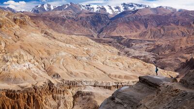 Nepal, Mustang. A trekker enjoying the extraordinary landscape on the approach to Dhi and Yara. Getty Images