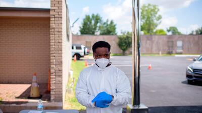 A healthcare worker puts on additional personal protective equipment at a Covid-19 testing site in Houston, Texas. AFP