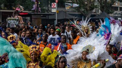 Performers and revellers dance in the street during the Notting Hill Carnival in London on Monday. Getty