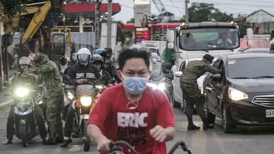 Members of the Philippine Army wearing protective masks take the temperature of travelers entering into Metro Manila. Bloomberg