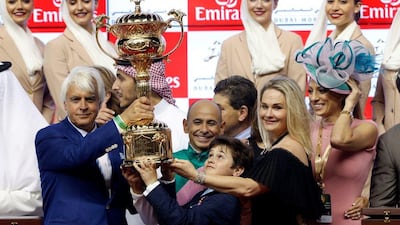 Arrogate trainer Bob Baffer, left, and jockey Mike Smith centre, lift the Dubai World Cup following Arrogates victory at Meydan Racecourse. Ahmed Jadallah / Reuters
