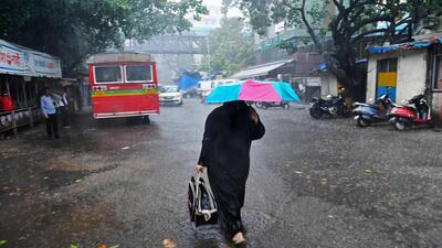 A woman walks along a road in Mumbai, India, after Cyclone Tauktae caused heavy rain. AFP