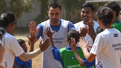 Xavi gives Indian children high fives.