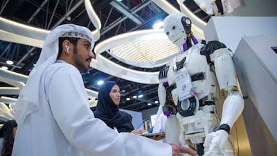A man interacts with a robot at the Abu Dhabi Government stand
