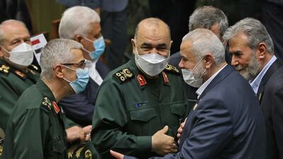 The leader of the Palestinian Hamas movement, Ismail Haniyeh shakes hands with the commander of Iran's Revolutionary Guard force, General Hossein Salami during the swearing in ceremony.