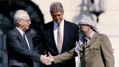 From right, PLO chairman Yasser Arafat shakes hands with Israeli leader Yitzhak Rabin as Bill Clinton looks on after the signing of the Oslo Peace Accords on September 13, 1993. Reuters