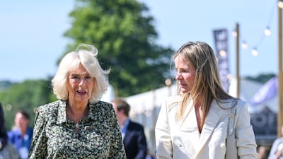 The queen consort, wearing a green floral Fiona Clare dress, walks with Lady Rothermere at the Daily Mail Chalke Valley History Festival on June 20, 2022. Getty Images