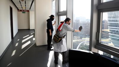 Protesters look out of windows for police positions. Reuters