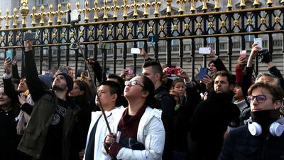 Tourists take pictures outside Buckingham Palace after Prince Harry announced his engagement to Meghan Markle, in London. Darrin Zammit Lupi / Reuters